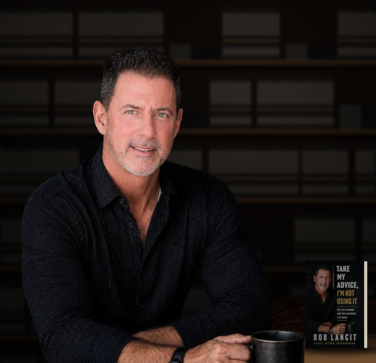 Rob Lancit at a table with his coffee mug and a copy of his book beside him, shelves of the same book behind him (photo illustration)